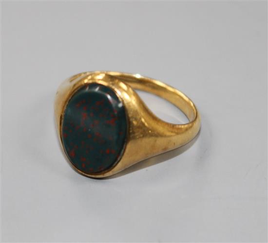 An early 20th century yellow metal and bloodstone set oval signet ring, size P.